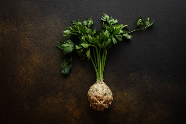 Celery root with tops close-up Celery root with tops close-up on a brown background, top view, organic autumn seasonal root crops Celeriac stock pictures, royalty-free photos & images