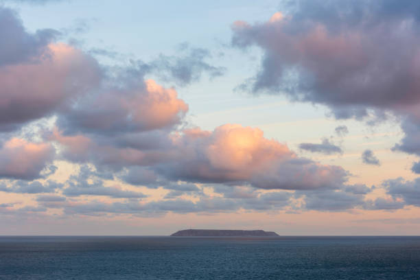 magnifiques formations nuageuses au lever du soleil et couleur sur l’île lundy sur la côte du devonshire en angleterre à la fin de l’été - hartland point lighthouse photos et images de collection