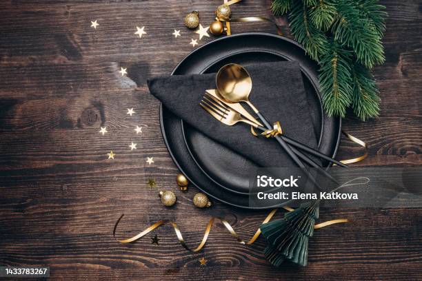 Christmas Table Setting Black Plates And Gold Decor Stock Photo - Download Image Now