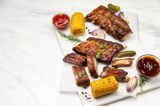 Grilled pork ribs with barbecue sauce and ketchup and grilled vegetables