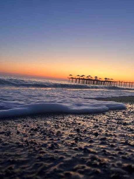 istock Beautiful sunset at a wavy beach covered in tiny rocks 1433786237