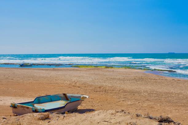 istock Old fishing boat on a sandy beach under a clear blue sky 1433786507