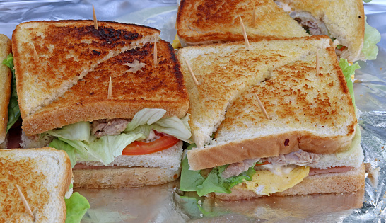 Various California-style sandwiches on a foil tray