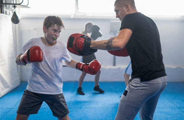 istock Group Of Kids Practicing With Instructor Boxing At Gym 1433790487
