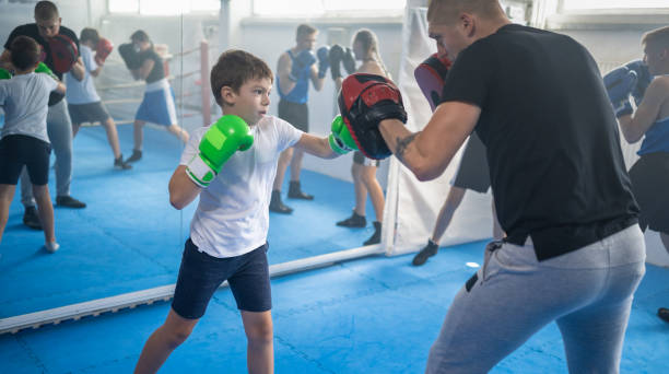 istock Group Of Kids Practicing With Instructor Boxing At Gym 1433790511