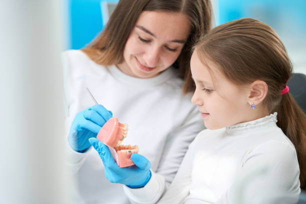 istock Friendly dentist explaining structure of teeth to pleased preadolescent girl 1433793520