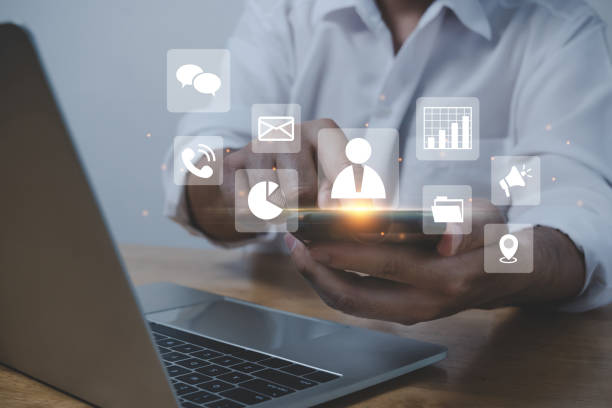 istock Contact Us. businessman hand touching on mobile smart phone and computer with virtual social media icon diagram, business finance, internet data technology, digital marketing, social network concept 1433794478