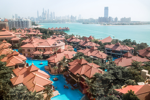 Dubai, UAE - September 30, 2022:  Swimming pool on the Palm Jumeirah with people relaxing and sunbathing by the water