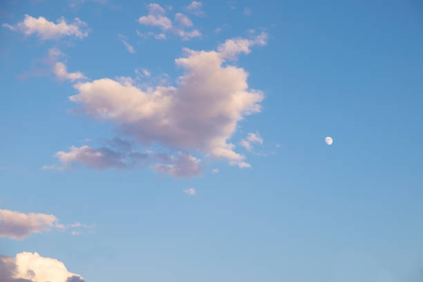 Heart-shaped clouds and a small moon, dusk