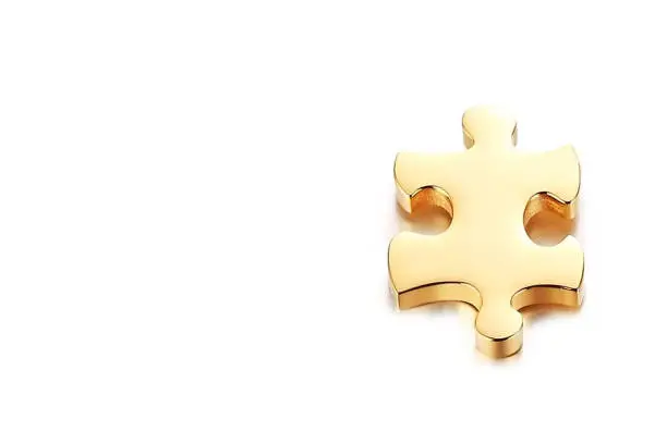 Gold puzzle piece with copy space on white background