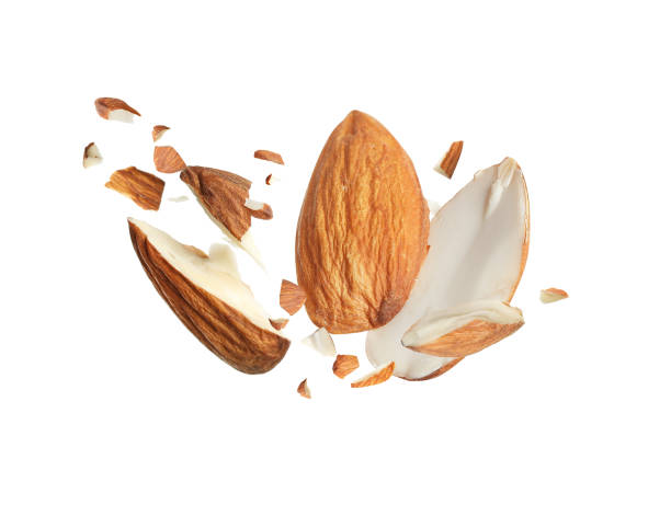 istock Pieces of tasty almonds falling on white background 1433806415