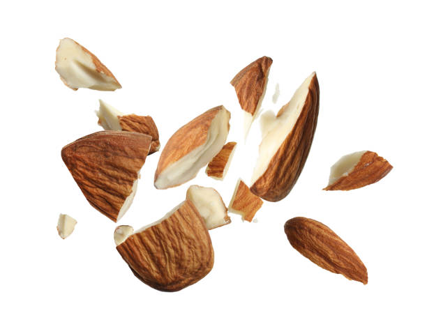 istock Pieces of tasty almonds falling on white background 1433806435
