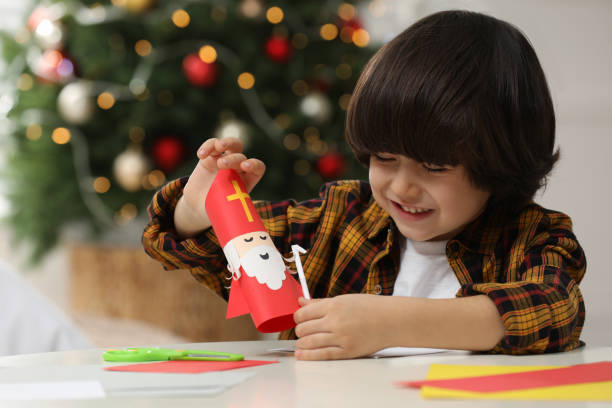 istock Cute little boy making paper Saint Nicholas toy at home 1433807214