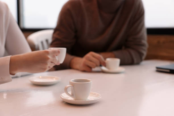 istock Coworkers enjoying coffee during break in cafe, focus on cup. Space for text 1433811720