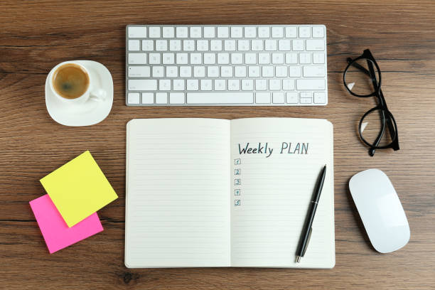 istock Flat lay composition of notebook with weekly plan on wooden table 1433812203