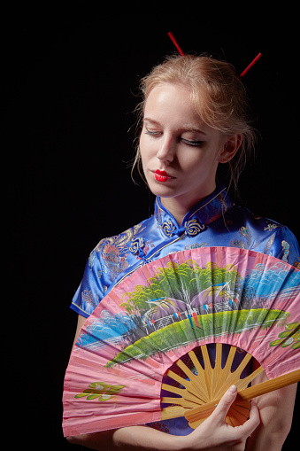 girl in japanese dress with fan on black background