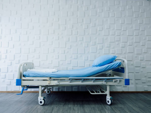 istock An empty adjustable patient bed with blue bedsheet and pillow on white background in a hospital room. Health care, medical and insurance concept. Variable height bed, medical equipment. 1433814229