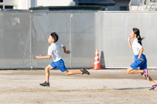 Japanese elementary school students running in the school playground