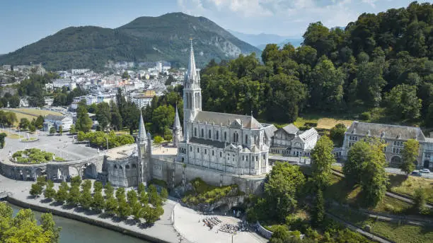 Famous Sanctuary of Our lady of Lourdes - Rosary Basilica Aerial Drone View - World famous Pilgrim destination. Cathedral of Lourdes,  Grotte de Massabille. Lourdes is a small market town lying in the foothills of the Pyrenees, famous for the Marian apparitions of Our Lady of Lourdes that are reported to have occurred in 1858 to Bernadette Soubirous. Our Lady of Lourdes Basilica in Lourdes, Lourdes,  Hautes-Pyrenees, France, Europe