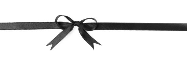 istock Elegant black ribbon with bow isolated on white, top view 1433820520