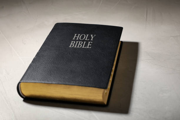 Old hardcover Bible on grey table. Religious book