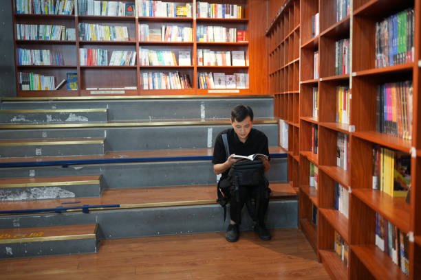 ein junge liest bücher, um sein wissen zu erweitern. - book staircase steps single object stock-fotos und bilder
