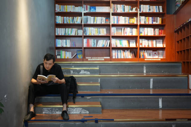 ein junge liest bücher, um sein wissen zu erweitern. - book staircase steps single object stock-fotos und bilder