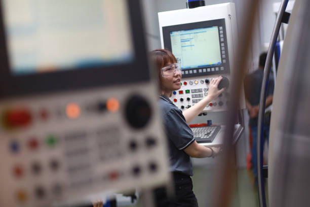 Female Asian Engineer Working On A Machine In Factory stock photo