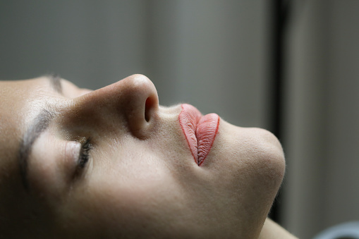 Young woman on a permanent lips make-up treatment. About 25 years old, Caucasian female.