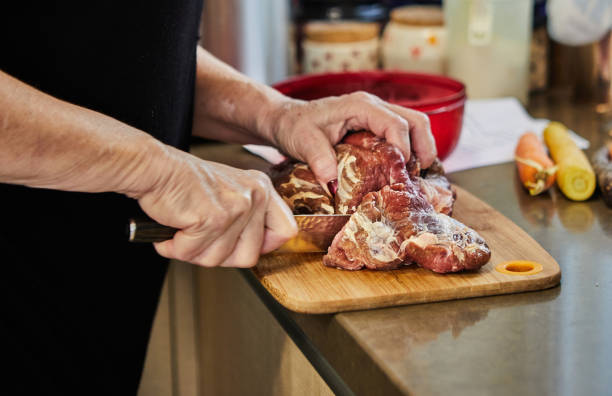 istock Chef cuts the beef with knife and prepares it for baking in the oven 1433834322