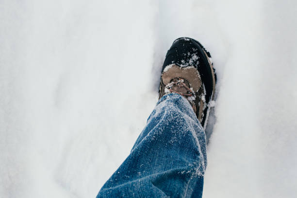 istock Male leg walking in snow, blue jeans 1433840691
