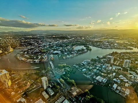 Gold Coast, Australia - April 25, 2021: Aerial panorama view of High-rise building sky scrapers with inland island and Surfer Paradise city skyline landscape with Sunset light in the evening.