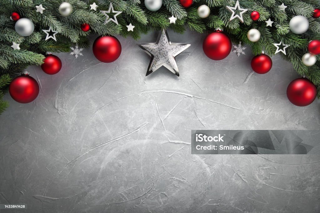 Christmas background with arch-shaped border Elegant modern Christmas background with an arch-shaped border composed of fir branches, red and silver baubles and stars, on gray textured surface as copy space Christmas Stock Photo
