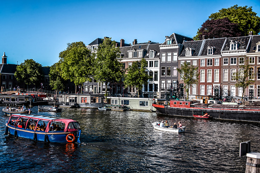 Bustling Boat Tourism Of Amsterdam Canal, The Netherlands
