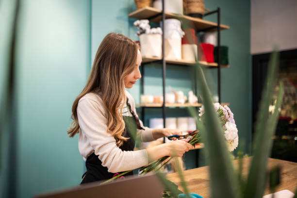 istock Beautiful young florist at flower shop working 1433846530
