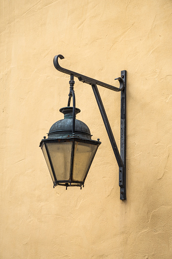 Photo of a vintage hanging lantern, mounted on a yellow wall
