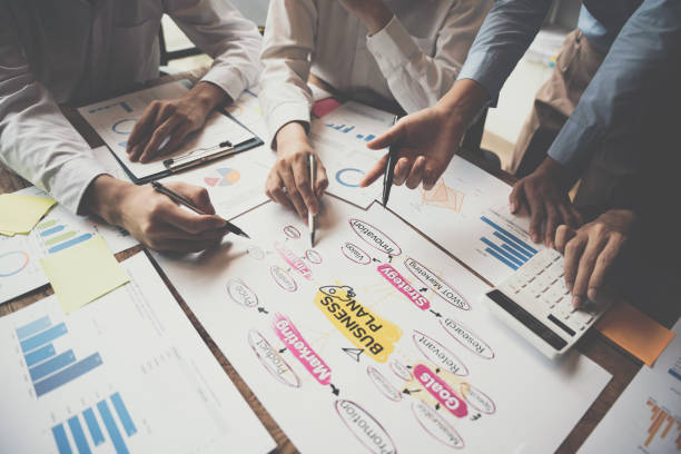 istock Close-up of businesspeople hands pointing a business plan sheet data,discussing, analyzing and brainstorming. 1433855746
