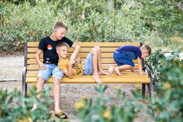 istock Siblings enjoy playing together sitting on wooden bench 1433855807