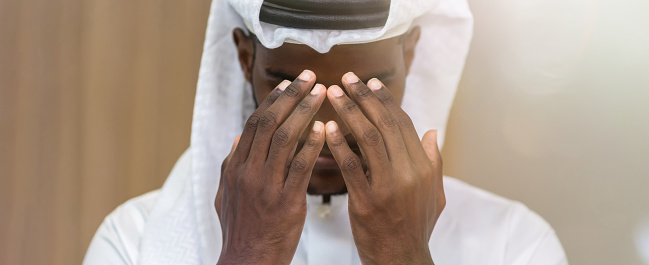 Hombre musulmán que tiene adoración. Hombre árabe musulmán rezando en la mezquita extendiendo las palmas hacia arriba. Oración musulmana photo