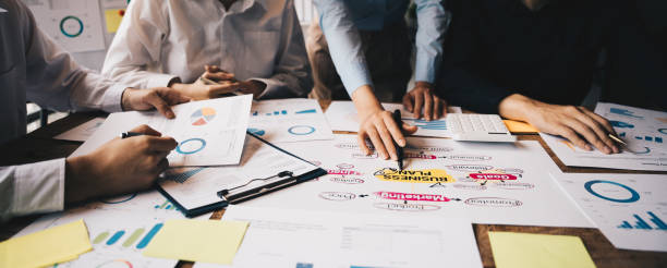 istock Close-up of businesspeople hands pointing a business plan data and donut chart, analyzing financial reports, team work concept. 1433856312