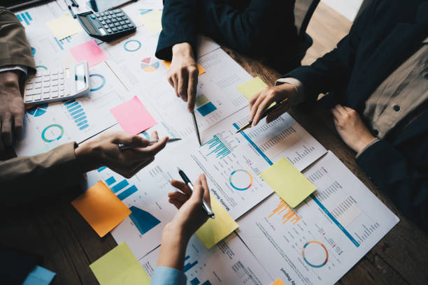 istock Team Business people are analyzing and brainstorming, hands pointing at Monthly Budged document at office, Teamwork Brainstorming concept. 1433856693