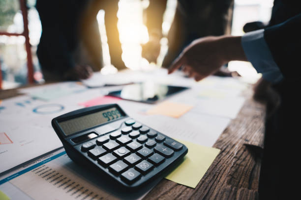 istock Calculator laying on financial report, Business colleagues analyzing on a background. 1433858037