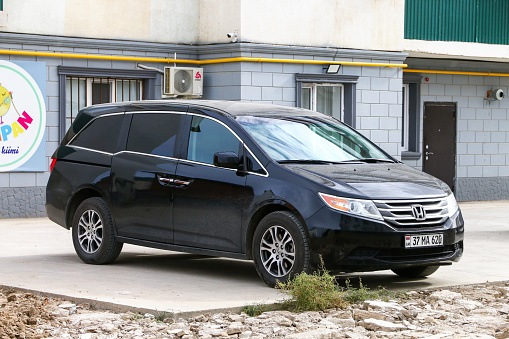 Atyrau, Kazakhstan - October 14, 2022: Black minivan Honda Odyssey in the city street.