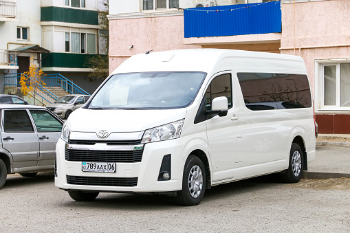 Atyrau, Kazakhstan - October 13, 2022: White van Toyota HiAce (H300) in the city street.