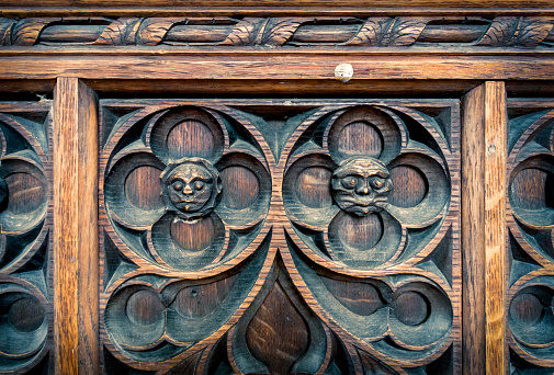 Comical carved faces on a wooden panel in St Nicholas’ Chapel in King’s Lynn, Norfolk, Eastern England.