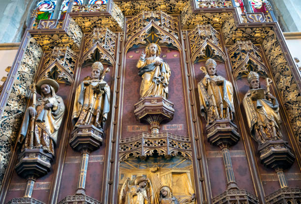 Jesus Christ and saints on the reredos in King's Lynn Minster Jesus Christ with some of the saints depicted on the reredos in the Minster church of St Margaret, King’s Lynn, in Norfolk, Eastern England. The saints seen here are St Jerome, St Gregory, St Augustine and St Ambrose and, creepily, all the figures appear to be looking straight at the viewer. The reredos was designed and installed by GF Bodley in 1899 during renovation by Sir George Gilbert Scott. The church dates from 1101AD and was founded by Herbert de Losinga, Bishop of Norwich. kings lynn stock pictures, royalty-free photos & images