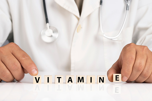 Doctor and cubes with text Vitamin E
