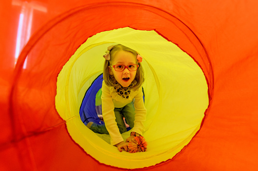 Girl living with cerebral palsy playing in sensory room, snoezelen, during therapy session. People with cerebral palsy can have problems swallowing and commonly have eye muscle imbalance.