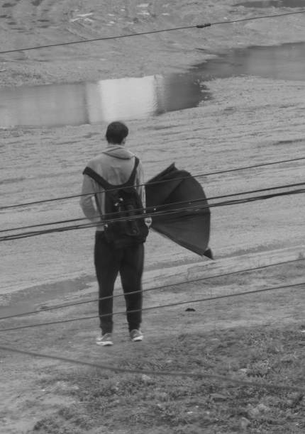 Sydney, Darlin Harbour, NSW, Australia - October 19, 2025: Closeup rear view of walking mature male on Darling Harbour Pyrmont Bridge, black and white