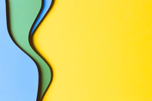 istock Abstract colored paper texture background. Minimal paper cut style composition with layers of geometric shapes and lines in yellow, light blue and green colors. Top view 1433889126
